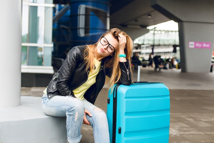 portrait-pretty-girl-with-long-hair-glasses-sitting-outside-airport-she-wears-yellow-sweater-with-black-jacket-jeans-she-leaned-suitcase-is-bored-waiting_1_8cad6.jpg